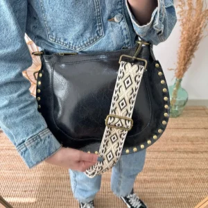 Bandolera ovalada piel tachuelas negra iniciales bordadas herrajes cobre