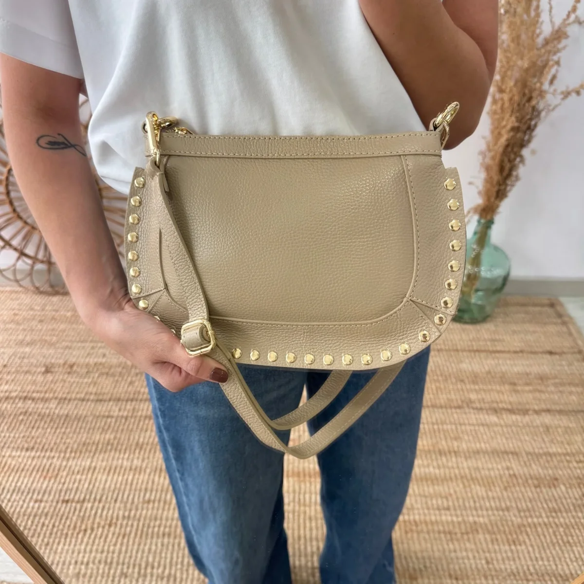 Bandolera ovalada piel tachuelas taupe iniciales bordadas