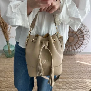 Bolso bucket piel taupe pompón iniciales bordadas