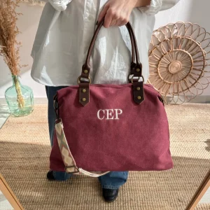 Bolso combinado loneta y piel granate iniciales bordadas con correa étnica