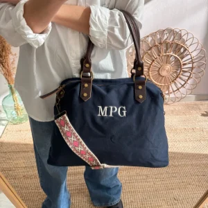 Bolso combinado loneta y piel azul marino iniciales bordadas con correa étnica